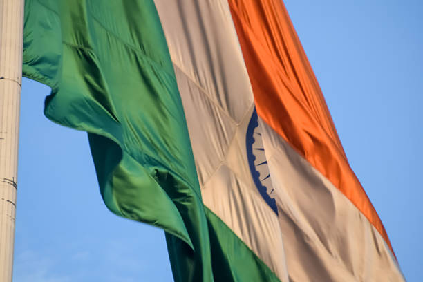 istock India flag flying high at Connaught Place with pride with plain white background, India flag fluttering, Indian Flag on Independence Day and Republic Day of India, tilt up shot, Har Ghar Tiranga 2214614916