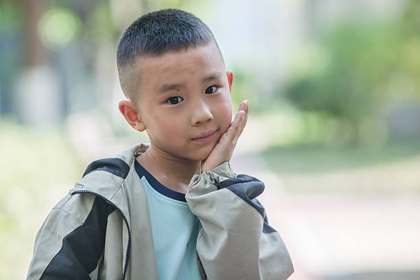 child looking through his hands. White background