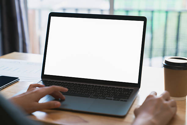 istock Businessman hand typing on laptop and working on computer on wooden table, screen blank mockup. 2214618955
