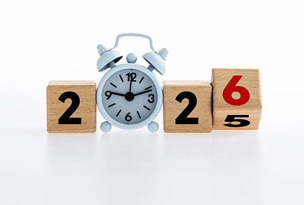 istock Turned a wooden cube and changed number 2025 to 2026 with small white alarm clock 2214619103