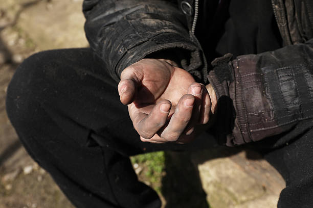 Poor homeless man with dirty hands outdoors, closeup