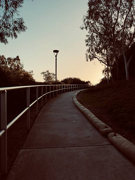 istock A concrete path winds through a park in Carlsbad, California, at sunset. 2214619527