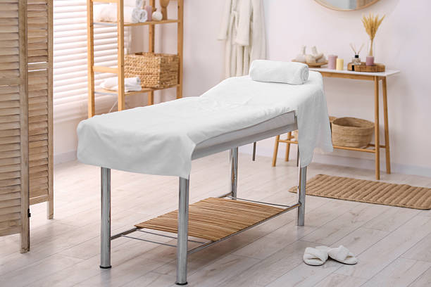 istock Comfortable massage table with clean towels in spa center 2214620531