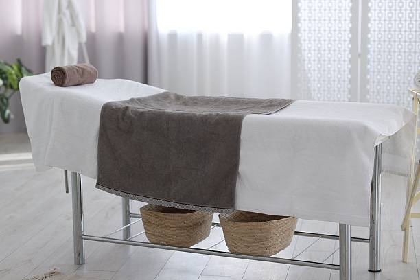 istock Comfortable massage table with clean towels in spa center 2214620540