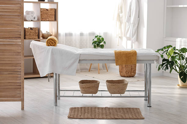 istock Comfortable massage table with clean towels in spa center 2214620542