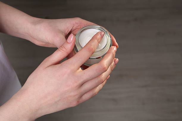 istock Woman applying hand cream indoors, above view 2214620576