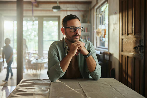 istock Carefree man day dreaming at the table at home. 2214620965
