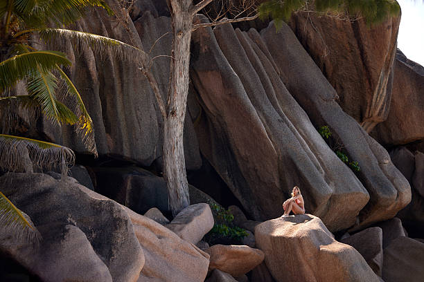 Young woman relaxing with her eyes closed during summer day on a rock. Copy space.