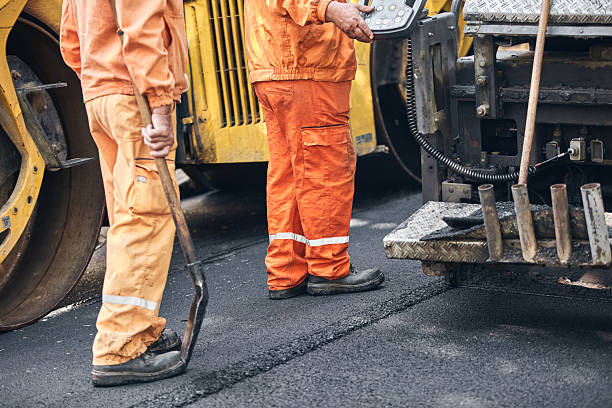 istock Construction workers working on a new asphalt layer on a public street. 2214627376