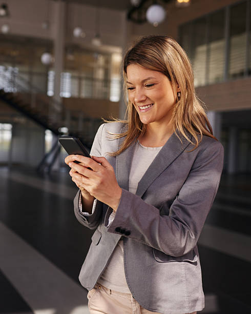 istock Happy businesswoman using cell phone in a hallway. 2214627593