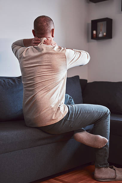 istock Man with neck pain at home. 2214627729