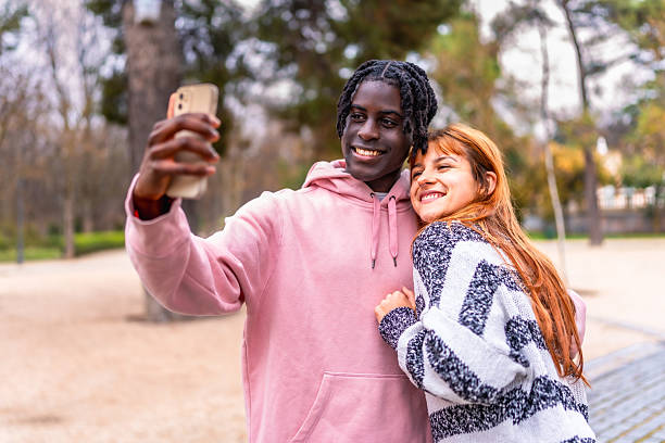 istock Young couple taking a selfie in the park 2214628554