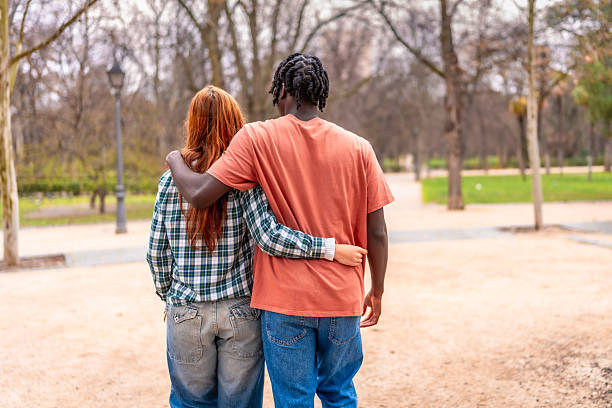 istock Interracial couple walking together in a park 2214628570
