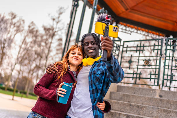 istock Two young content creators filming with smartphone and gimbal in park 2214628599