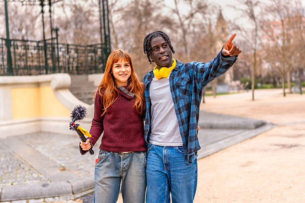 istock Two young filmmakers creating content in a park 2214628612