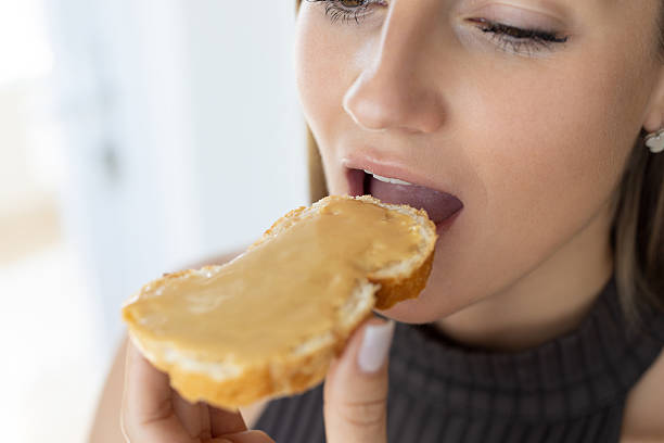 istock Beautiful female eating bread with peanut butter 2214633469