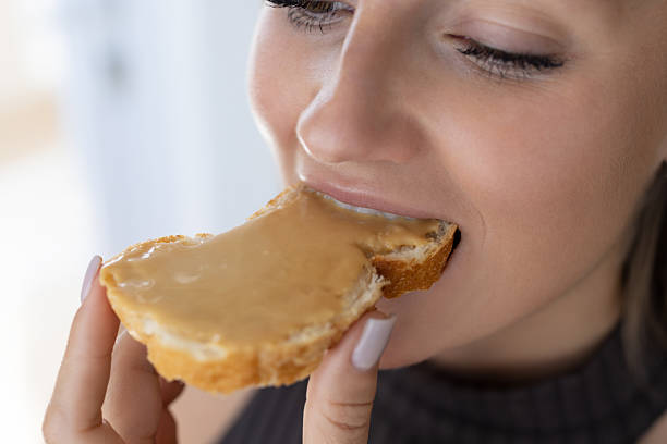 istock Beautiful female eating bread with peanut butter 2214633572