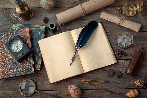 istock Globe, telescope, lamp, divider, old coins, shell, map, shell, book, compass, hourglass, quill pen on wood desk. Columbus Day, exploration and nautical theme vintage background. 2214633665