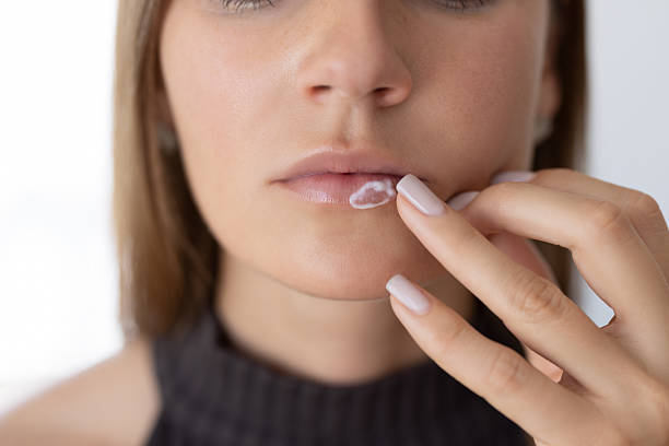 istock Female applying moisturiser into her lips 2214633888
