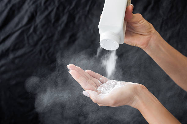Female hand with talcum powder isolated on black backgroun