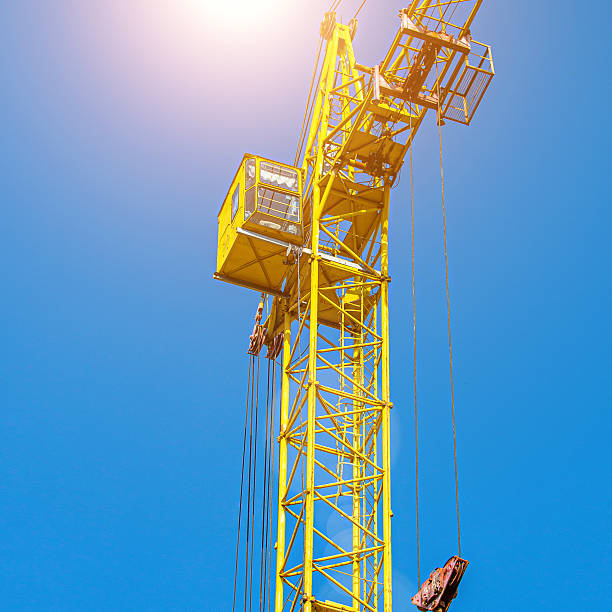 istock Tall building under construction with scaffolds,Freestanding tower crane on a building site.Building construction site work against blue sky 2214636035