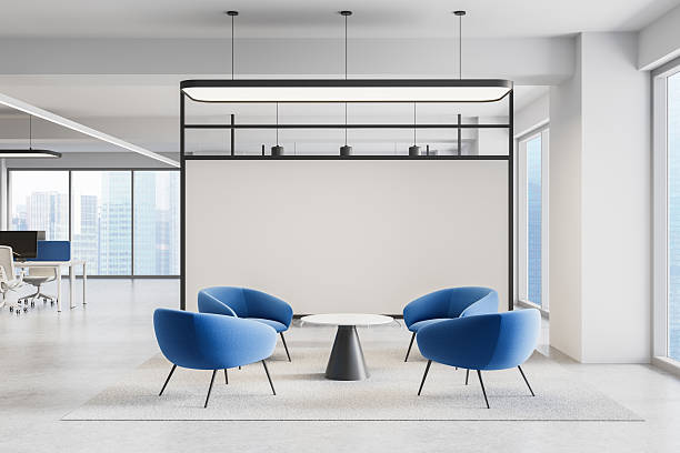 istock Modern office lounge area with four blue chairs and round table on carpet, surrounded by glass windows and minimal white walls. 3D Rendering. 3D Rendering 2214636932
