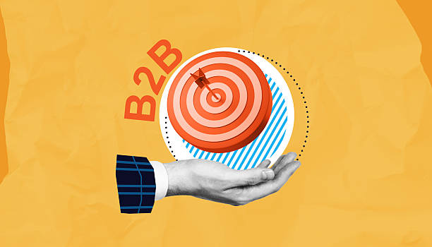 istock B2B marketing target concept with hand holding bullseye on yellow background. 2214637406