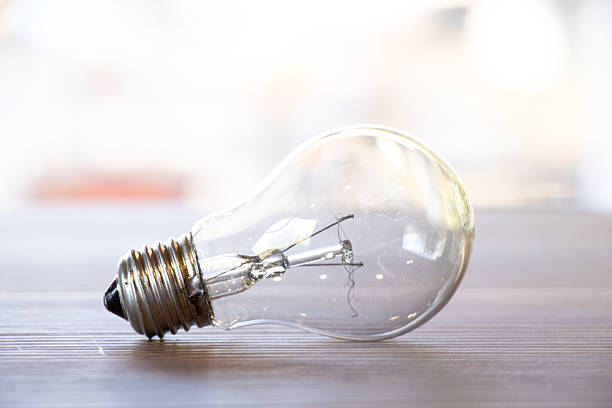Broken spiral of a light bulb that lies on a table outside, a broken heating lamp