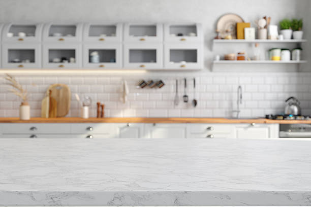 istock Empty White Marble Countertop With Blurred Kitchen Cabinets In The Background 2214643801