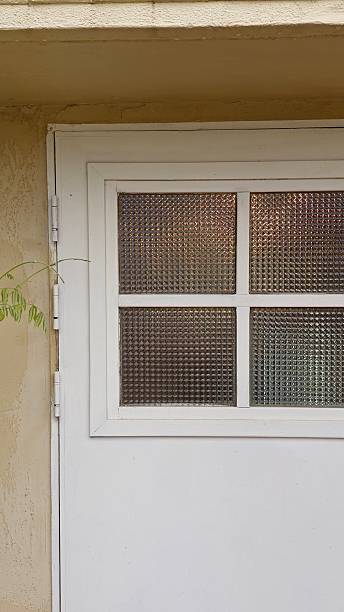 White Textured Glass Door with Brass Handle Framed by Soft Greenery