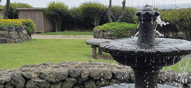 istock Tranquil Garden Fountain Surrounded by Stone Walls and Greenery 2214644488