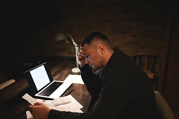 istock Stressed businessman working late at night in dark home office 2214644813