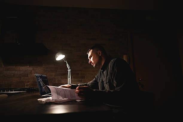 istock Focused businessman working late at night in dark home office 2214644923