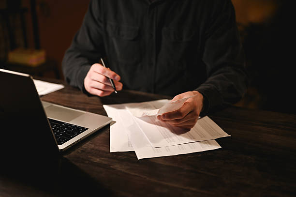 istock Businessman working late reading documents at his desk 2214644984