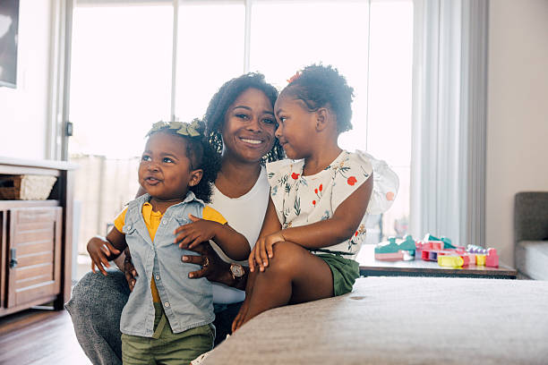 istock Single mother playing with her two daughters at home 2214646472