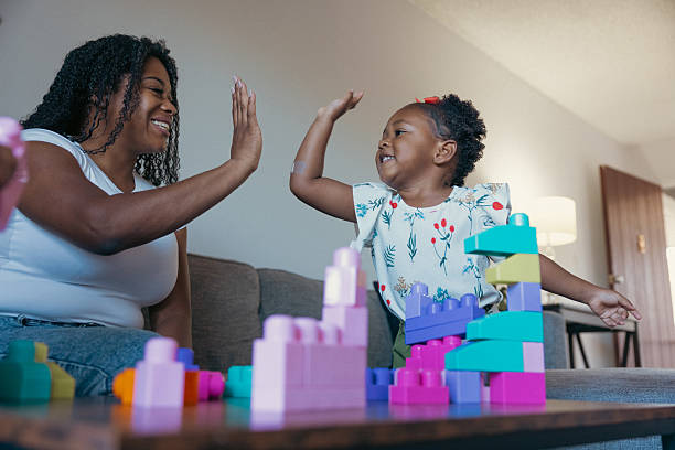 istock Single mother playing with her two daughters at home 2214646612