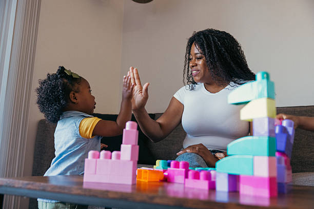 istock Single mother playing with her two daughters at home 2214646634