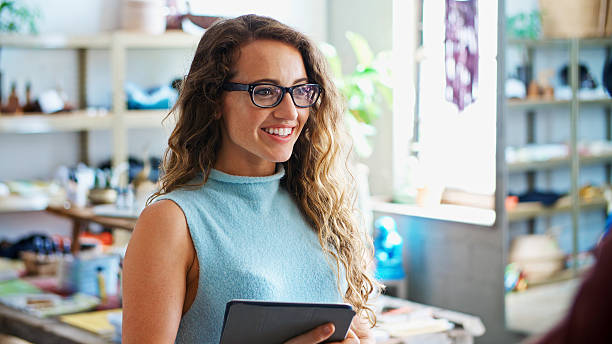 istock Female Sales Assistant With Digital Tablet Talking With Customer 2214646706