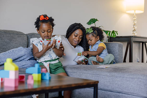 istock Single mother playing with her two daughters at home 2214646970