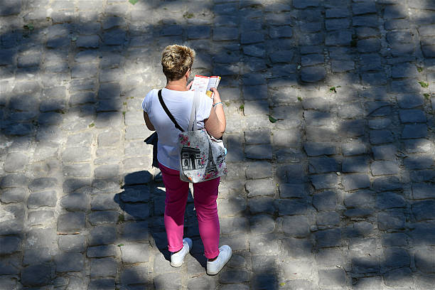 Paris, France-05 10 2025: Rear view of a people reading a guidebook on a street in Paris, France.