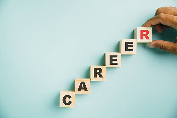 istock hand placing a wooden cube block labeled CAREER on a blue background 2214650479