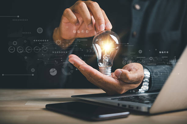 istock Businessman protects a glowing light bulb, symbolizing creativity and innovation 2214650512