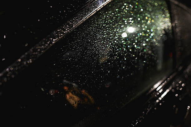 istock Raindrops covering car window at night reflecting city lights 2214651244