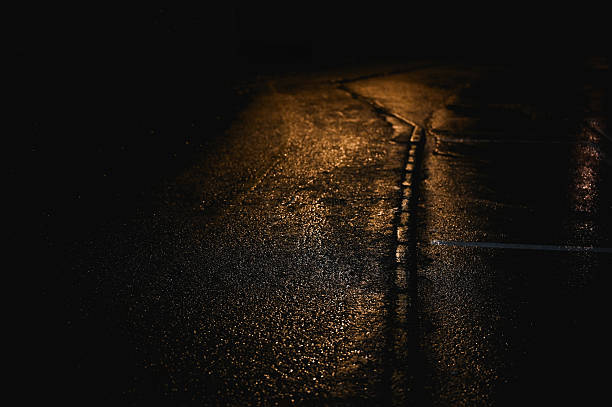 Wet asphalt road at night reflecting street lights