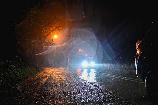 istock Driving on a rainy night with approaching headlights and street lights 2214651349