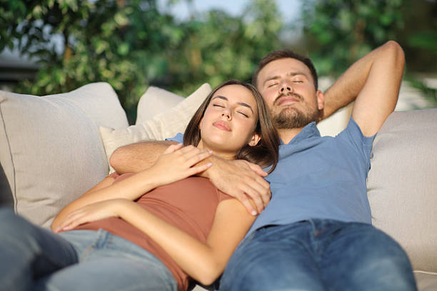 istock Couple relaxing sleeping on a couch in a garden 2214653955