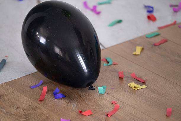 istock Black Balloon on Floor with Confetti 2214654306