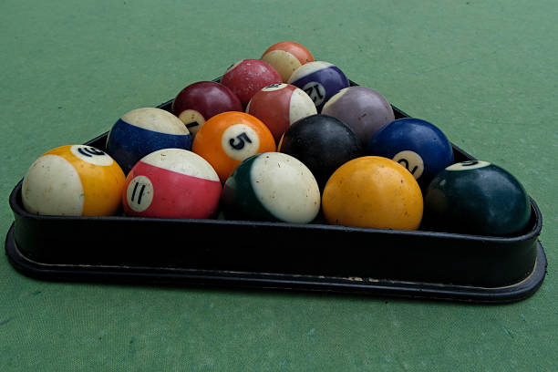 istock Billiard balls in a billiard triangle on a green background, close-up 2214656637