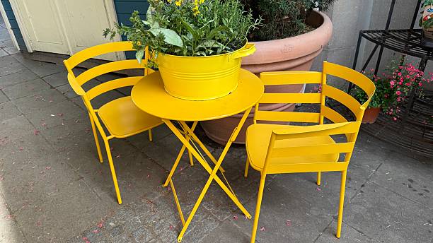 istock Yellow round table and 2 chairs, yellow flower pot on the table 2214657075