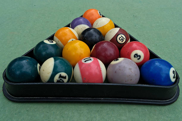 istock Billiard balls in a billiard triangle on a green background, close-up 2214657731